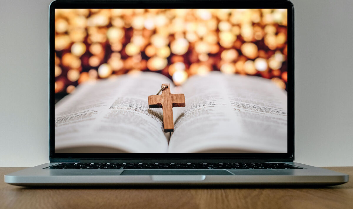 Bible and cross on laptop screen