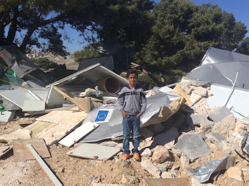 Boy standing amongst rubble in Palestine